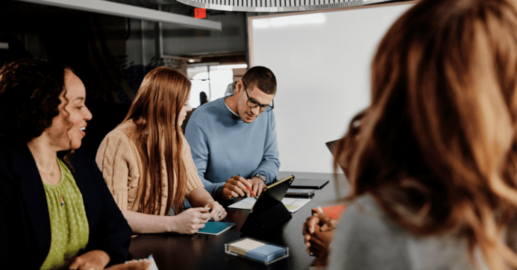 A group of colleagues sitting and talking at a table together.